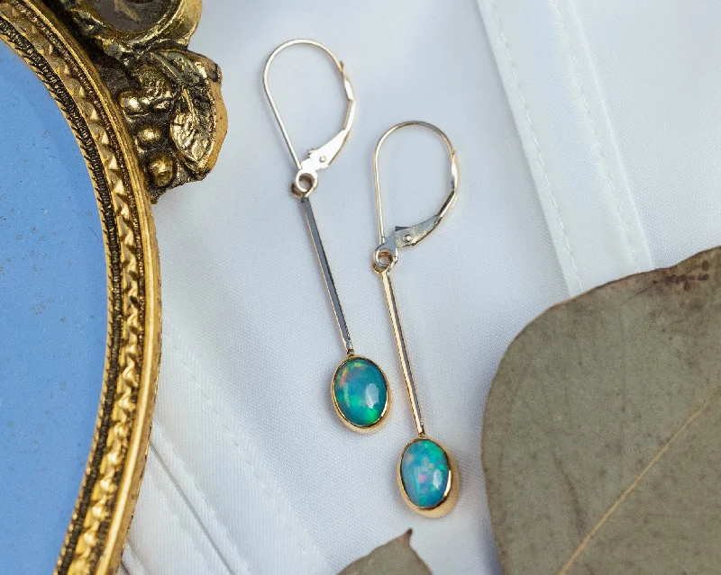 Subtle aquamarine drop earrings evoking serene sea tones -OVAL BEZEL SET ETHIOPIAN OPAL DROP EARRINGS IN 14K YELLOW GOLD